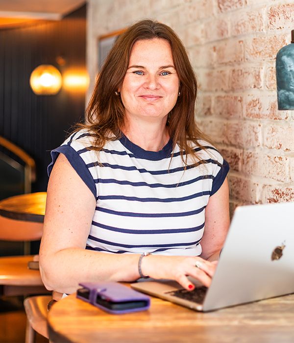 Emma Culver sitting at table with open laptop.