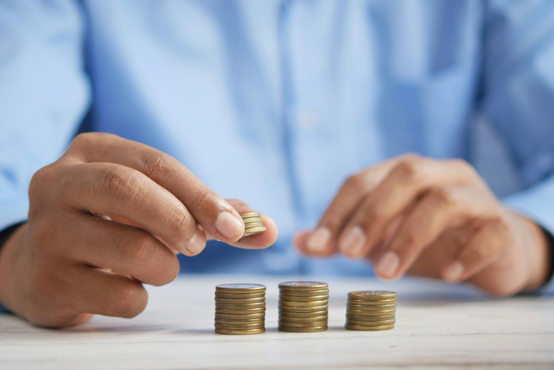 Person stacking coins on top of a table